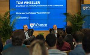 Tom Wheeler and Kevin Werbach sit on a stage with an audience in the foreground