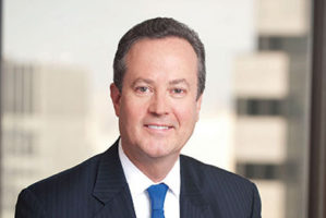 Headshot of Douglas Peterson in front of a brightly lit window