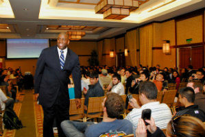 Magic Johnson walks through the aisle of an audience of students