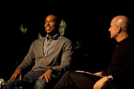 Chris Bridges, also known as Ludacris, sits on stage with Bobby Turner