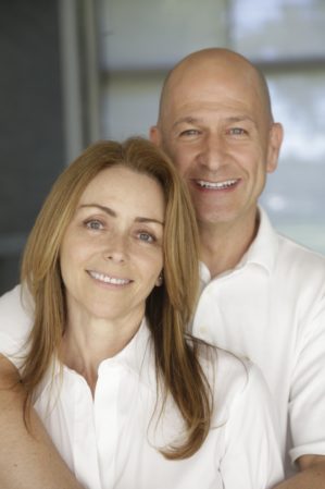 Bobby Turner drapes his arm around his wife, Lauren Turner, who stands in front of him