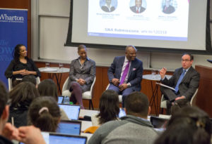 Stephanie Creary, Wendy Freeman Carr, Oris Stuart, and Martin L. Schmelkin sit at the front of a classroom full of students