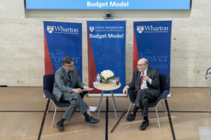 Overhead view of Alan Greenspan and Kent Smetters sitting on a stage, in conversation