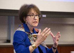 Charlene Barshefsky wearing a blue blouse in conversation with Dean Geoff Garrett