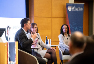 Stephanie Creary, Jeff Smith, and Janet Foutty sit in chairs on a stage, in discussion