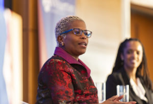 Close-up of Carloynn Johnson speaking to an audience with Stephanie Creary beside her