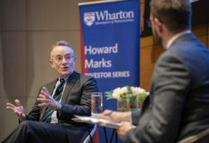 Howard Marks and Chris Geczy in chairs on stage, in discussion